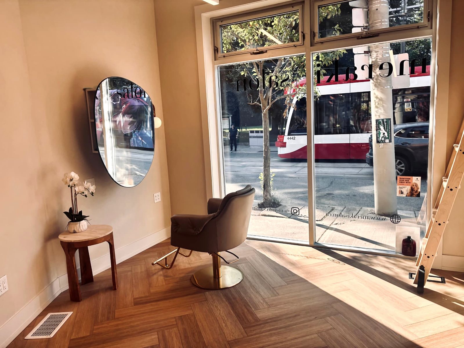 The street-facing window and chair at Meraki Salon on King Street East — look for the Meraki Salon lettering on the glass